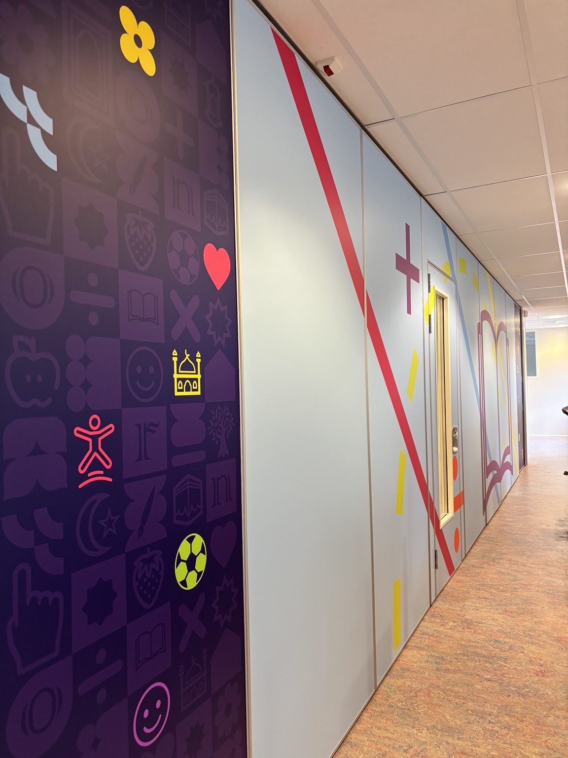 Grote grafische wandbekleding in het interieur van basisschool Al Kitaab
