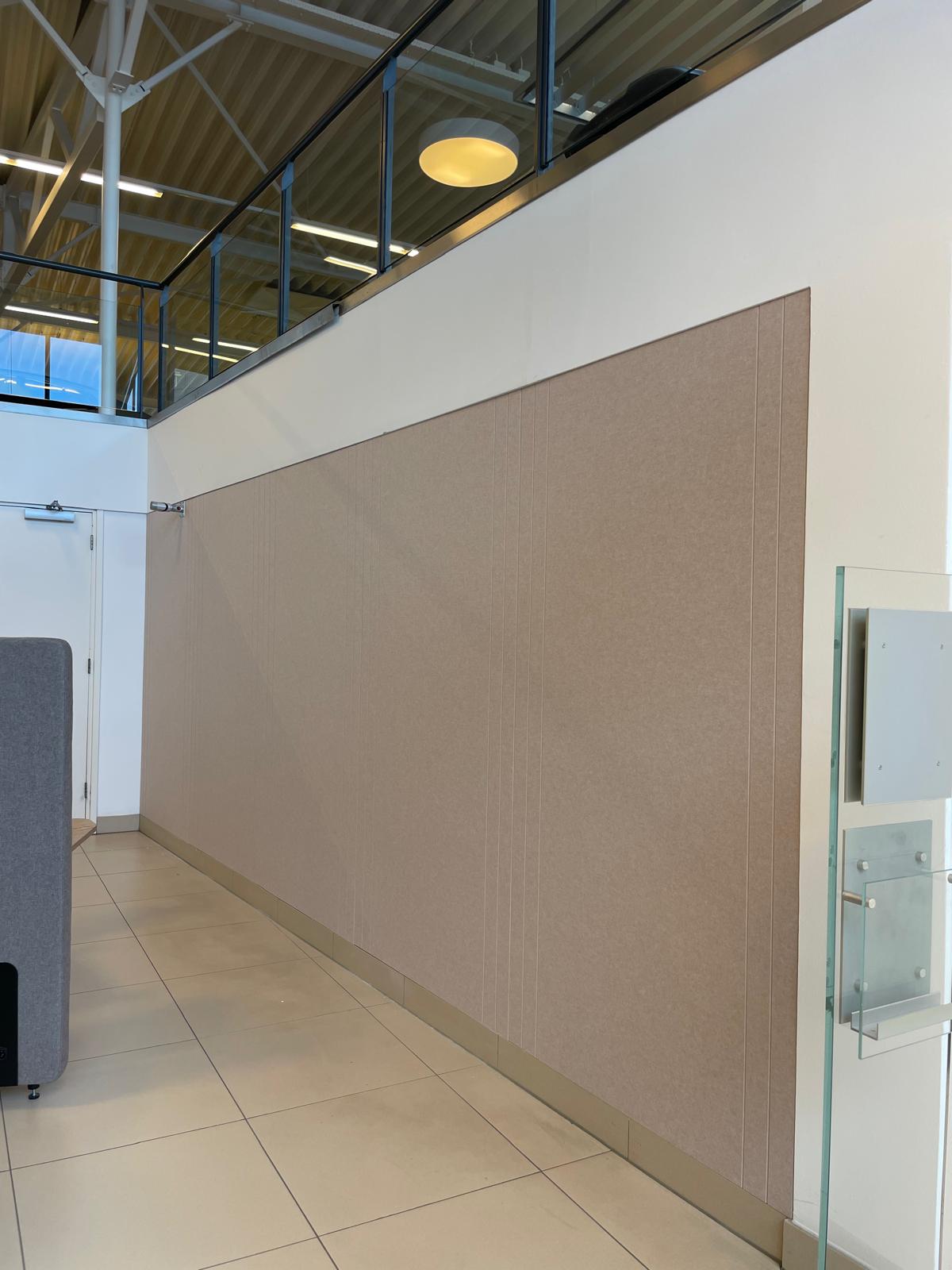 De volledig beklede taupekleurige vilten wand bij Ekris